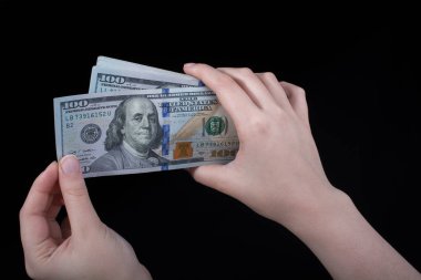 Beyaz arka planda el ele tutuşan Amerikan doları banknotları