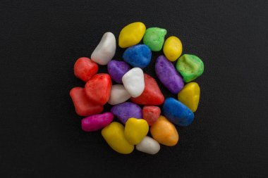 Siyah arkaplanda küçük renkli çakıl yığınları