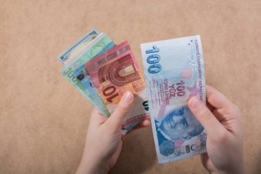 El ele tutuşan Amerikan doları banknotları ahşap arka planda izole edilmiş.