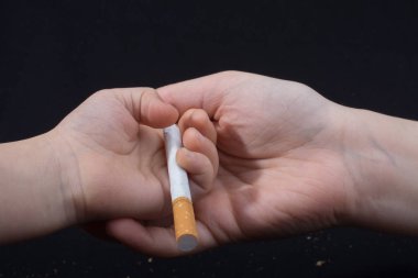 El siyah arka plan üzerinde sigara dışarı veren