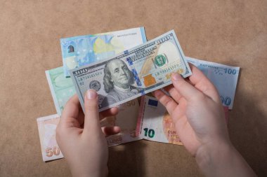 Amerikan Doları üzerinde ahşap arka plan izole tutan el