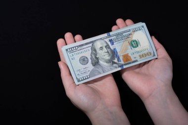 Beyaz arka planda el ele tutuşan Amerikan doları banknotları