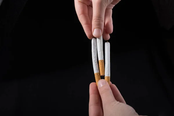 Mano Sta Distribuendo Sigarette Uno Sfondo Nero — Foto Stock
