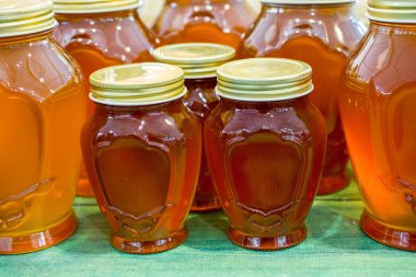 Kapaklı taze bal dolu cam kavanoz.