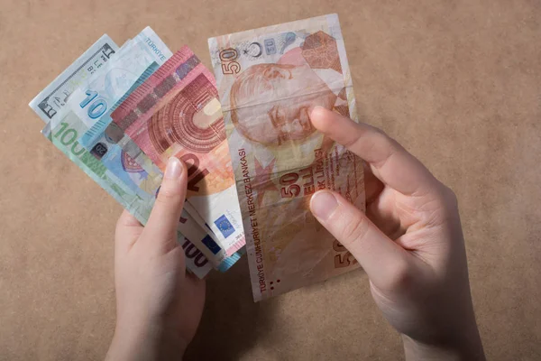 El ele tutuşan Amerikan doları banknotları ahşap arka planda izole edilmiş.