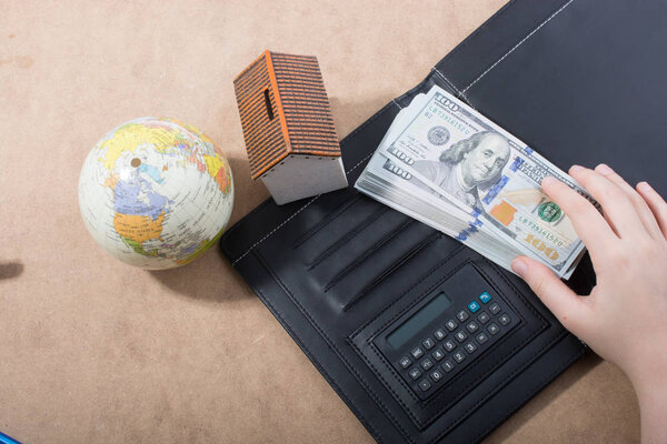 Hand holding American dollar  banknotes isolated on wooden background