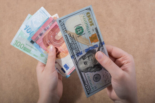 Hand holding American dollar  banknotes isolated on wooden background