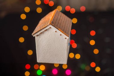 Bokeh ışıklı arka planda küçük bir model ev