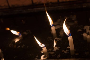 Karanlıkta mum ışığında yanan mumlar.