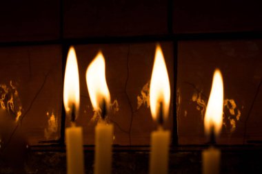 Karanlıkta mum ışığında yanan mumlar.