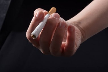 El siyah arka plan üzerinde sigara dışarı veren