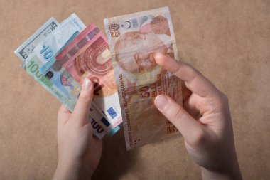 Amerikan Doları üzerinde ahşap arka plan izole tutan el