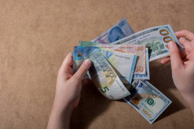 Amerikan Doları üzerinde ahşap arka plan izole tutan el