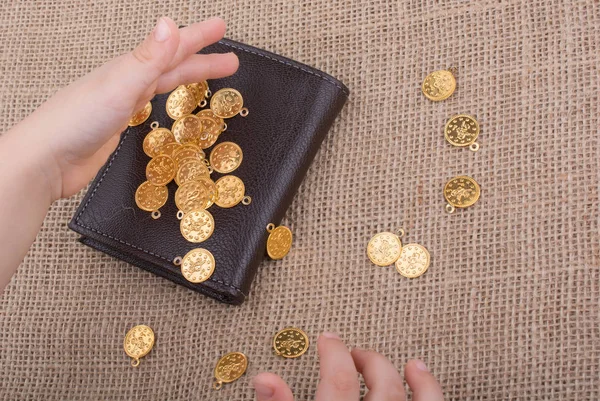 Monedero y monedas de oro falsas en lienzo — Foto de Stock