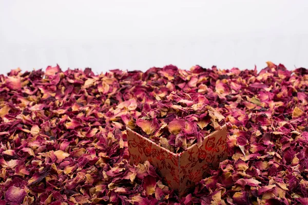 Лепестки роз в коробке и в качестве фона — стоковое фото