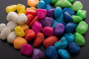 Siyah arkaplanda küçük renkli çakıl yığınları