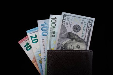 El ele tutuşan Amerikan doları banknotları siyah arka planda izole edilmiş.