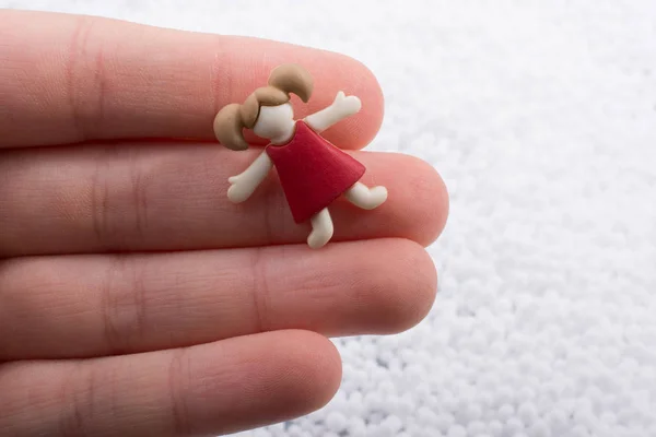 Petite figurine fille à la main sur fond blanc — Photo