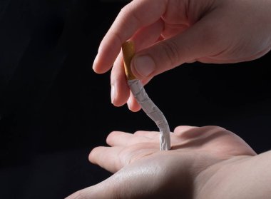 El siyah arka plan üzerine bir sigara kırılıyor