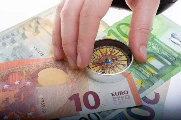 La celebración de la mano brújula en billetes en euros como negocio, co — Foto de Stock