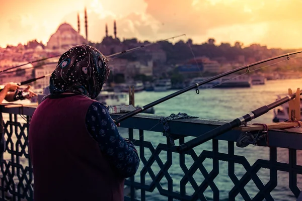 Gammal kvinna som fiskar på Galatabron. Semester i Istanbul. — Stockfoto