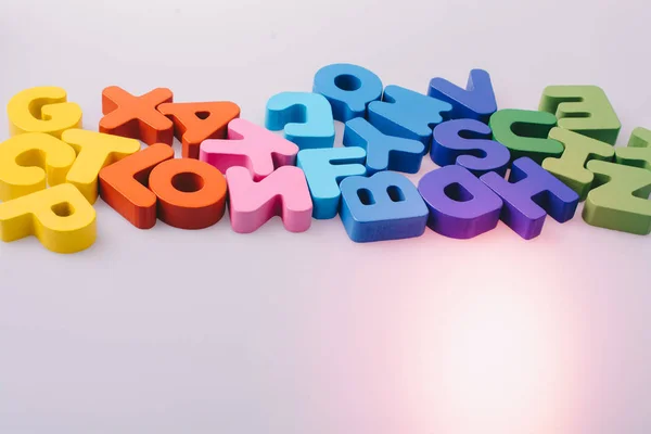Blocchi di lettere colorati sparsi casualmente sul bianco — Foto Stock