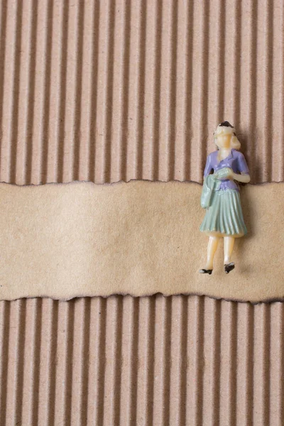 Woman figurine on piece of burnt paper — Stock Photo, Image