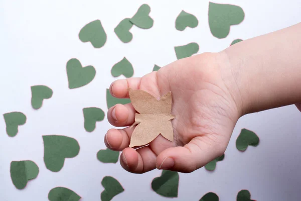 Mariposa de papel y corazones de papel en mano —  Fotos de Stock