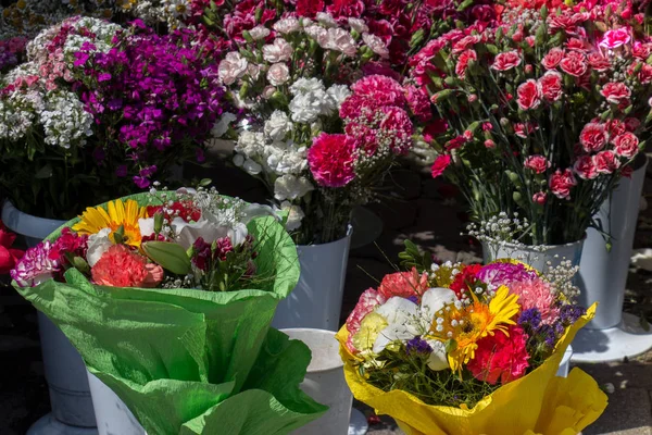 Барвисті квіти у вазі на квітковому ринку — стокове фото