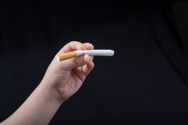 siyah arka plan üzerinde sigara tutan el