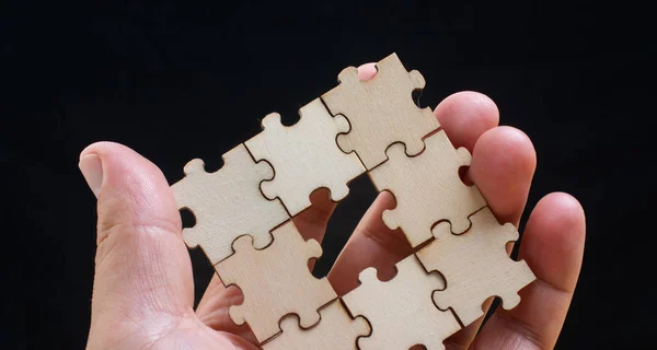 Рука чоловіка, який намагається з'єднати шматочки головоломки — стокове фото