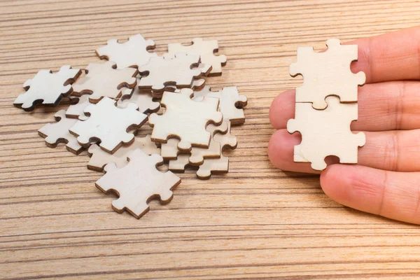Hand of male trying to connect pieces of jigsaw puzzle — Stock Photo, Image