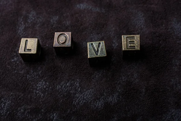 Das Wort Liebe mit Metallbuchstaben auf dunklem Hintergrund Love conc — Stockfoto