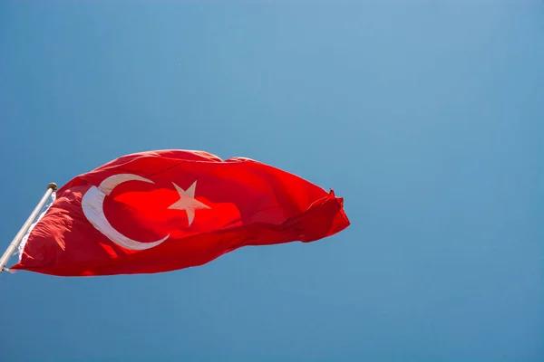 Turkish national flag with white star and moon in sky