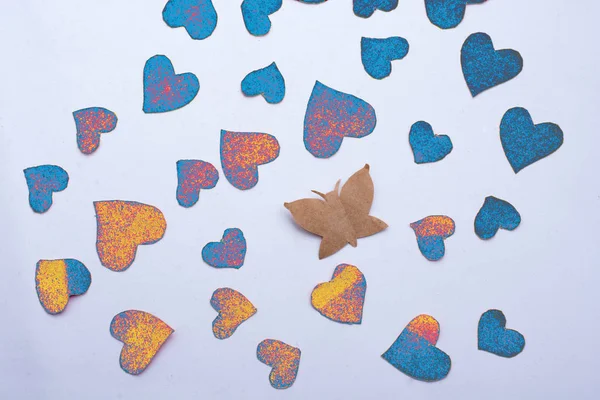 Mariposa de papel y corazones de papel en rojo — Foto de Stock