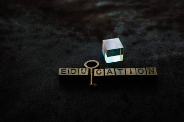 Prism beside retro styled metallic decorative key and education 