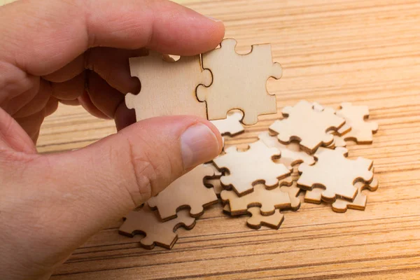 Рука мужчины пытается соединить кусочки головоломки — стоковое фото