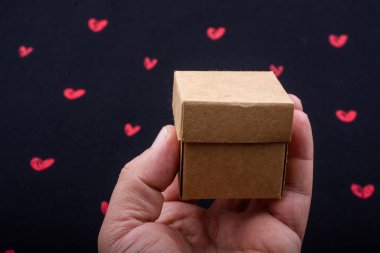 Kalp ile arka planda karton kutu tutan el