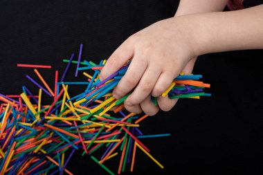 Yaratıcılık için renkli ahşap çubuklarla oynayan çocuk