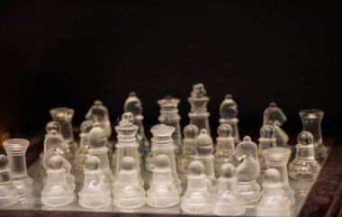 Intellectual game - chess. Glass chess pieces on the chessboard