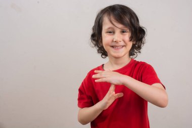 Gülümseyen küçük çocuk bir duraklama veya mola zaman el hareketi yapma