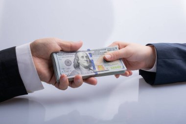 İş adamı Amerikan doları banknot parası veriyor ve alıyor.