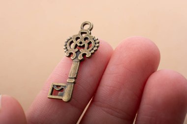 Elinde eski moda dekoratif bir anahtar var.