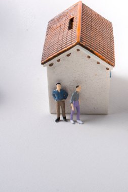 Evin önünde minyatür bir insan figürü.