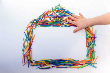 Yaratıcı konsept olarak renkli çubuklardan yapılmış ev şekli