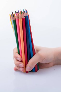 Beyaz arkaplana yerleştirilmiş el ele tutuşan kalemler