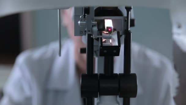 Un dispositivo medico oftalmologico per il controllo della vista. Medico non riconoscibile che lavora con test oculistici del paziente . — Video Stock