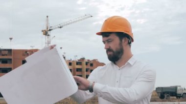 Bir inşaatta çalışma planı ile inşaat mühendisi.