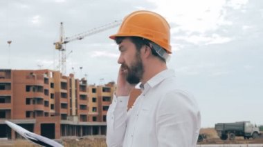 İnşaat alanında cep telefonuyla konuşurken mimar.