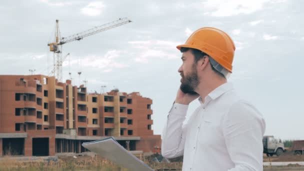 Architecte parlant sur un téléphone portable sur un chantier de construction . — Video